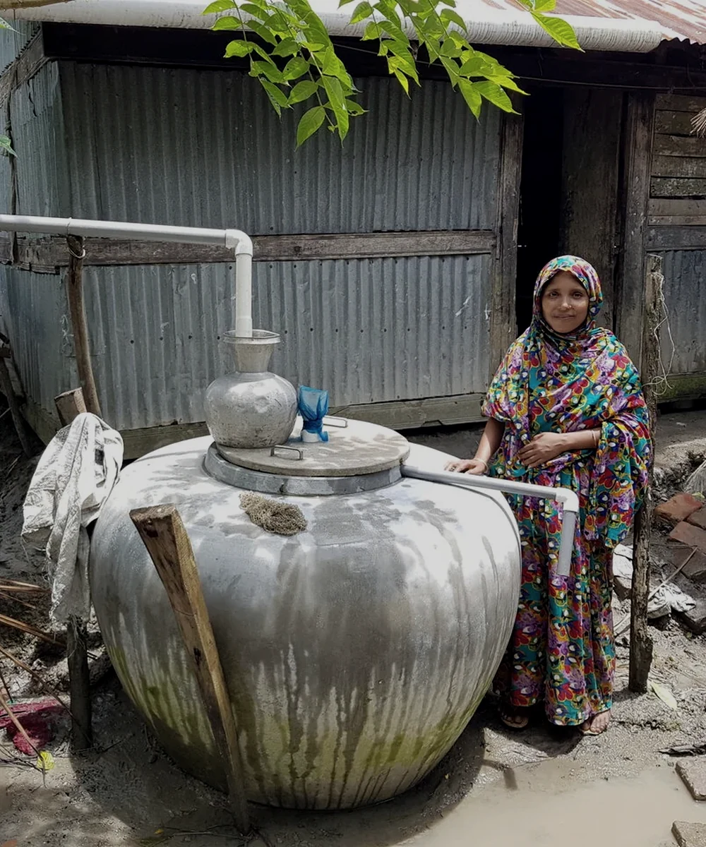 A woman beside a coastal household water system