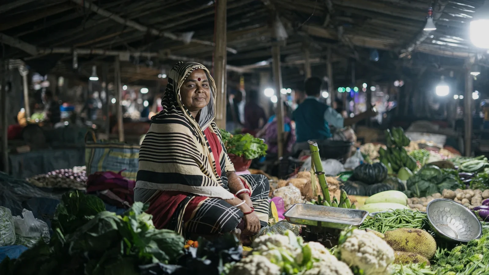 Woman working among fresh vegetables in a wholesale market