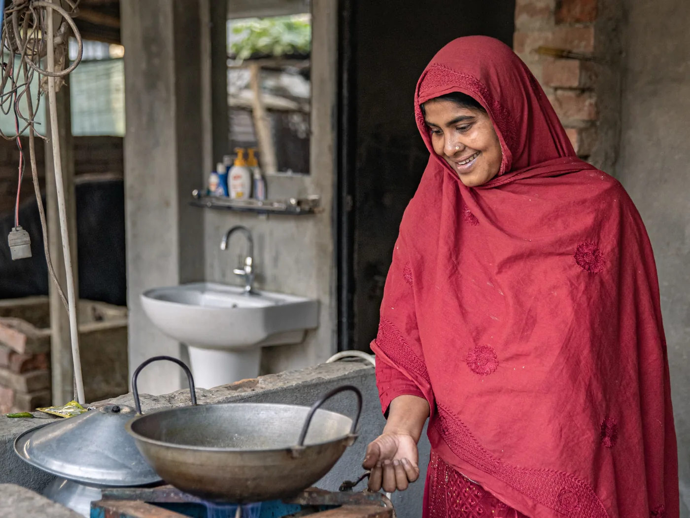 A woman cooking with a Green Flame biogas stove