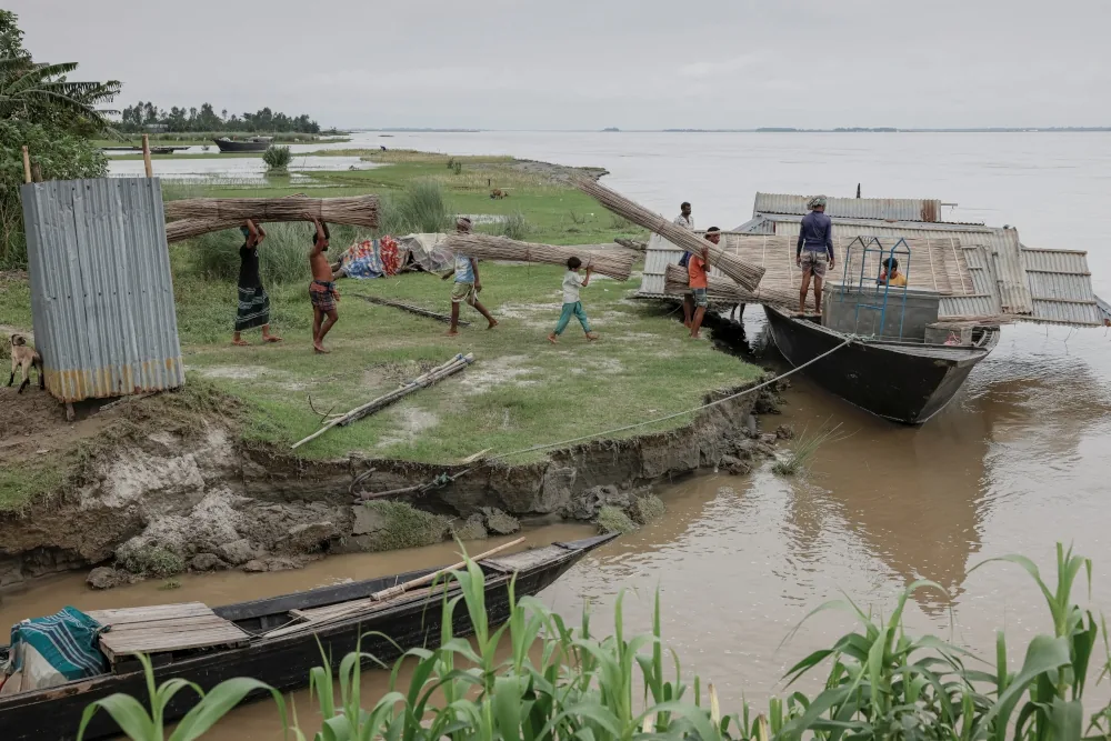 People moving materials from a river boat onto an exposed char edge
